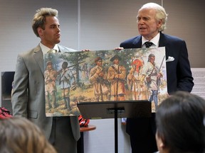 Cory Skyler Drouillard, left, and Chris Harris discuss how they believe a local man, George Drouillard, born in Sandwich in the 1770s, was responsible for guiding the Lewis and Clark expedition west of the Mississippi River. They are holding a drawing with a question mark over Sacagawea, who has been viewed as Lewis and Clark's guide.