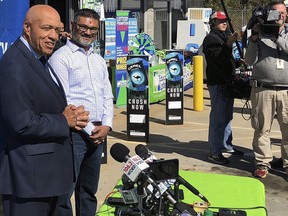 In this Wednesday, Oct. 24, 2018 file photo, South Carolina Education Lottery Chief Operating Officer Tony Cooper, left, and KC Mart owner CJ Patel, right, speaks to reporters about the winning ticket sold at the Simpsonville, S.C., store. (AP Photo/Jeffrey Collins, File)