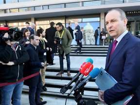 Ireland's opposition Fianna Fail party leader, Micheal Martin (R) speaks to members of the media as he arrives at Dublin Castle in Dublin, Ireland on Feb. 15, 2019, to attend the All-Island Civic Dialogue on Brexit. With just 43 days until Britain is due to leave the European Union, EU leaders increasingly fear Theresa May is playing a dangerous game of chicken. Prime Minister May has made a great show of reopening talks with Brussels, but officials here say she is playing for time until a no-deal divorce is imminent.