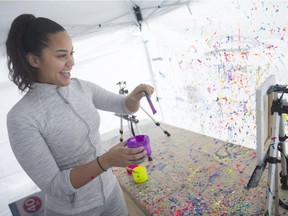 Oliviana Cinco, 22, a 4th year arts student, splashes acrylic paint on an eight-by-ten canvas in the mobile splatter tent at the University of Windsor on Wednesday, February 27, 2019.
