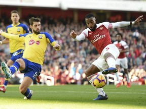 Southampton's Jack Stephens, left, and Arsenal's Alexandre Lacazette in action during their English Premier League soccer match at the Emirates Stadium in London, Sunday Feb. 24, 2019. (Joe Giddens/PA via AP) ORG XMIT: LRC803