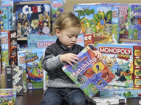 Aaron Evans Jr. checks out some of the games donated by businessman Sam Sinjari to the local Children's Aid Society during a  ceremony presentation on Wednesday, Feb. 13, 2019.