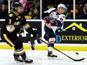 Windsor Spitfires' Nathan Staios (44) shoots while being defended by Sarnia Sting's Nick Grima (7) in the second period at Progressive Auto Sales Arena in Sarnia, Ont., on Friday, Feb. 15, 2019.