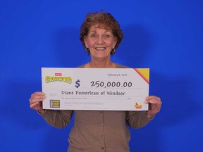 Diane Pomerleau of Windsor holds up the $250,000 prize cheque she won from playing Instant Crossword Deluxe. Photographed at the OLG's prize centre in Toronto on Feb. 5, 2019.
