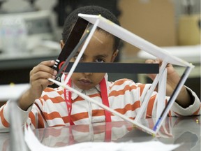 Six-year-old Yusuf Mohamed looks at the one-storey structure he and his brother built from pins and cardboard during a basic lesson of civil engineering at St. Clair College on Saturday, Feb. 23, 2019 as part of the Windsor-Essex chapter of Professional Engineers Ontarios ninth annual Innovation Station — Engineering Your Life event.