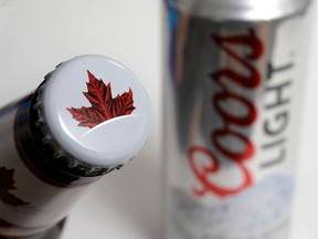 FILE- In this Nov. 28, 2017, file photo products from the Mondelez International family of brands, Molson beer, left, and Coors Light beer rest together, in Walpole, Mass. The Molson Coors Brewing Company reports financial results Tuesday, Feb. 12, 2019.