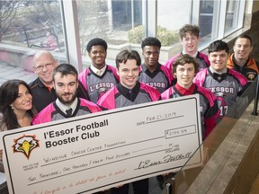 Houida Kassem, left, executive director of the Windsor Cancer Centre Foundation, welcomes members of the L'Essor football team, from left to right, head coach Mark Dupuis, Aydan Paisley, Jacob Austin, Ian Pearce, Ryan Nono, Wyatt Hanson, Max MacDougall, Nick Sylvestre, and coach Taylor Fratarcangeli, as they present a cheque for $2,194 to the Windsor Cancer Centre Foundation, Thursday, February 21, 2019.