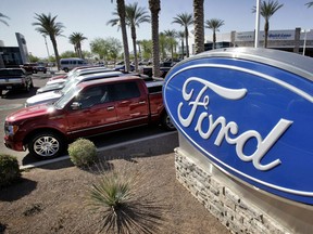 In this March 29, 2011 photo, new 2011 Ford F-150 trucks are shown at a dealership in Glbert, Ariz. Ford is recalling nearly 1.5 million pickup trucks in North America because the transmissions can suddenly downshift into first gear. The recall covers F-150 trucks from the 2011 through 2013 model years with six-speed automatic transmissions.