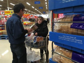 Julien Papineau, a Lakeshore farmer and past president of the Essex County Federation of Agriculture, was giving away free loaves of bread Tuesday at the Real Canadian Superstore on Walker Road for Canadian Agriculture Day. Here he is with shopper Claudia Bonanni of Windsor.
