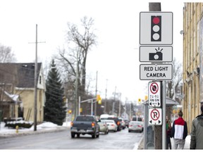 A sign alerts drivers to the presence of a red light camera at the intersection of Adelaide Street and Queens Avenue in London, Ont. on Thursday February 14, 2019.