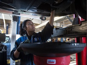 Olivia Saulteaux changes oil on a 2013 Subaru Tribeca at Auto Gallery Suburu on Winnipeg Street. An apprentice auto mechanic, Saulteaux is also a model and will travel to Paris to do a March 1 fashion show on the Eiffel Tower during Paris Fashion Week. The show will be part of International Indigenous Fashion Week, which was founded in Regina.