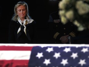 Rep. Debbie Dingell, D-Mich., stands near the casket of her husband and former Rep. John Dingell lying in repose in Dearborn, Mich., Monday, Feb. 11, 2019. John Dingell, the longest-serving member of Congress in American history, was first elected in 1955 and retired in 2014. The Democrat was 92.