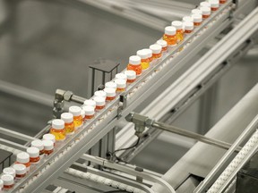 FILE- In this July 10, 2018, file photo bottles of medicine ride on a belt at the Express Scripts mail-in pharmacy warehouse in Florence, N.J. As Democrats in Congress consider whether to back a revamped regional trade pact being pushed by President Donald Trump, they're zeroing in on a new point of conflict: Drug prices. They contend that the new pact would force Americans to pay more for prescription drugs, and their argument has dimmed the outlook for one of Trump's signature causes.