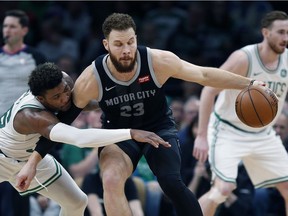 Boston Celtics' Marcus Smart, left, defends against Detroit Pistons' Blake Griffin, right, during the first half of an NBA basketball game in Boston, Wednesday, Feb. 13, 2019.