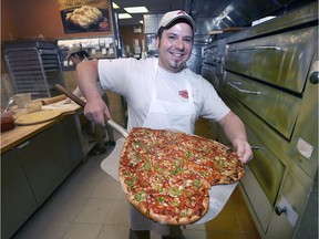 Tony Mannina displays a freshly made heart-shaped pizza at Antonino's Original Pizza on Howard Avenue in Windsor on Wednesday, Feb. 13, 2019. Each February the business donates $1 from the sale of each heart-shaped pizza to a heart-healthy charitable organization.