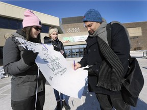 St. Clair College students Elyse Valoppi, left, and Yolanda Bueckert, who were part of a protest against the Ford government's proposed cuts to OSAP funding, collect a signature from fellow student Jamal Hashem on Feb. 1, 2019, at the college's main Windsor campus.