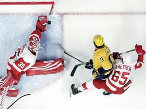 Detroit Red Wings goaltender Jimmy Howard (35) makes a stop on a shot by Nashville Predators left wing Filip Forsberg (9), of Sweden, during the first period of an NHL hockey game Tuesday, Feb. 12, 2019, in Nashville, Tenn. Also defending for Detroit is Danny DeKeyser (65).