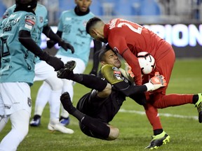 Toronto FC midfielder Jonathan Osorio (right) collides with Club Atletico Independiente goalkeeper Jose Guerra at BMO Field last night.  Nathan Denette/The Canadian Press