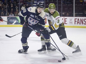 Windsor Spitfires rookie Jordan Frasca, who had a goal,  battles North Bay's Zack Malik for the puck during Saturday's OHL game at the WFCU Cenre.