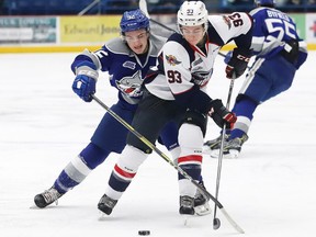 Blake Murray, left, of the Sudbury Wolves, and Jean-Luc Foudy, of the Windsor Spitfires, battle for the puck during OHL action at the Sudbury Community Arena on Friday.