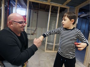 Adrian Beaulieu, 6, gives skilled tradesman Joe Cozzetto, left, a fist knock in the lower level of the family home Monday March 4, 2019.