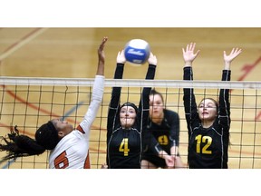 General Amherst's Lexi Dodds and Allison Dufour, right, attempt to block a smash by Biamba Kabengele of Burlington Corpus Christi during OFSSA girls' AA volleyball action at the St. Clair College SportsPlex.