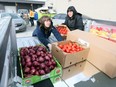 Helping hands. House of Sophrosyne case workers Nicole Wilson, left, and Shontelle Millender load up with fresh fruits and vegetables at the Unemployed Help Centre's Unifor Local 200 People's Choice Pantry in east Windsor on Tuesday.  Local food banks have begun emphasizing fresher, more nutritious offerings.
