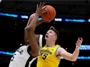 Cassius Winston of the Michigan State Spartans attempts a shot while being guarded by Jon Teske of the Michigan Wolverines in the second half during the championship game of the Big Ten Basketball Tournament at the United Center on March 17, 2019 in Chicago, Illinois.