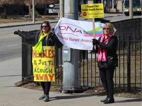 Ontario Nurses Association Local 8 member, left, and a supporter walk the picket line on Ouellette Avenue near Windsor Regional Hospital's Ouellette Campus Wednesday.