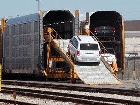 Dodge Grand Caravans and Chrysler Pacificas manufactured by FCA Windsor Assembly Plant are loaded onto rail cars from Motipark Automotive Storage on Kildare Boulevard Wednesday.