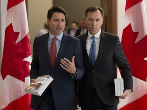 Prime Minister Justin Trudeau and Finance Minister Bill Morneau speak as they walk to the House of Commons in Ottawa, Tuesday March 19, 2019.