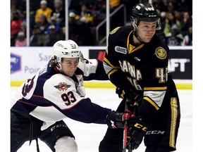 Windsor Spitfires' Jean-Luc Foudy (93) checks Sarnia Sting's Hugo Leufvenius (46) in the first period at Progressive Auto Sales Arena in Sarnia on Friday night.