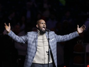 FILE - In this Nov. 17, 2015, file photo, musical artist R. Kelly performs the national anthem before an NBA basketball game between the Brooklyn Nets and the Atlanta Hawks in New York. The dilemma of separating the sides of R. Kelly, who faces 10 counts of aggravated sexual abuse, now confronts millions who listen to or perform his music.