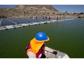 A worker on a boat approaches a floating island of solar panels at Los Bronces mine, about 65 kilometres from Santiago, Chile, March 14, 2019. Los Bronces is about 3,500 metres above sea level. In 2018, the mine produced 370,000 tons of fine copper and 2,421 tons of molybdenum.