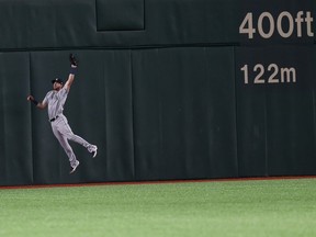 Seattle Mariners center fielder Mitch Haniger jumps to catch a fly ball hit by Oakland Athletics' Stephen Piscotty in the seventh inning of Game 1 of their Major League opening series baseball game at Tokyo Dome in Tokyo, Wednesday, March 20, 2019.
