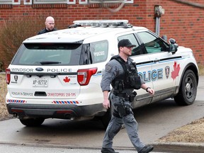 A member of the Windsor police Emergency Services Unit walks by a home at 3024 Grandview St. in the city's east end on March 14, 2019.