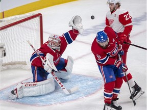 Montreal Canadiens goaltender Carey Price makes a save as Detroit Red Wings center Michael Rasmussen and Montreal Canadiens defenseman Shea Weber (6) look on during second period NHL hockey action Tuesday, March 12, 2019 in Montreal.