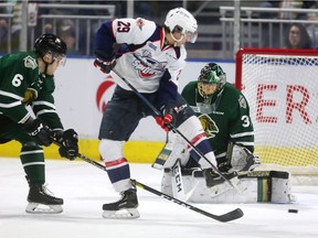Windsor Spitfires forward Daniel D'Amico tries to deflect a shot past London Knights goalie Jordan Kooy during Friday's series-opening game.