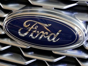 FILE- This Feb. 15, 2018, file photo shows a Ford logo on the grill of a car on display at the Pittsburgh Auto Show.