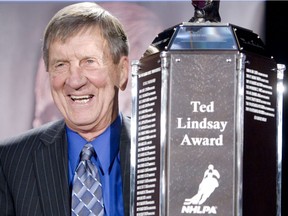 Hockey legend Ted Lindsay poses for photographs with the newly named Ted Lindsay Trophy during a press conference at the Hockey Hall of Fame in Toronto on April 29, 2010.