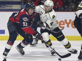 Windsor Spitfires rookie Jean-Luc Foudy, left, and London Knights defenceman William Lochead battle for the puck during Game 3 on Tuesday.