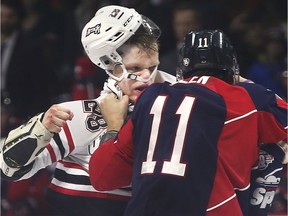 Owen Sound Attack defeneman Mark Woolley, left and Windsor Spitfires defenceman Sean Allen fight during the first period of Thursday's game at the WFCU Centre.
