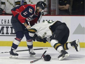 Windsor Spitfires defenceman Sean Allen, left, roughs up London Knights defenceman Evan Bouchard during Tuesday's playoff game at the WFCU Centre.