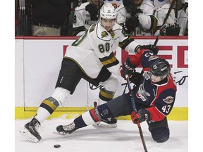 London Knights forward Alex Formenton, left, and Windsor Spitfires defenceman Louka Henault battle for the puck during Thursday's Game 4 of their playoff series at the WFCU Centre.