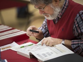 Cristian Popescu, of C&C Philatelics, examines some stamps at the Winpex 2019 Stamp Show and Exhibition at the Caboto Club on March 9, 2019.