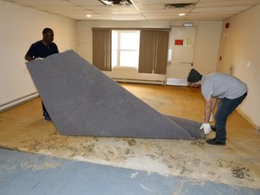 ALPHA House in Forest Glade is being restored as a community asset through a unique partnership between private investors, local non-profit organizations, and support from community members. The building was purchased by private investors, will become the new home of Matthew House Refugee Centre. In photo, Babatunde Lawal, left, and Khaled Omar remove old carpet from the former A.L.P.H.A. House.