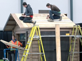 Adam Slikboer, top right, Josh Folkeringa and Chad Storey, left, all of LaSalle's Euroshed, assemble a 12-foot by eight-foot wooden shed which will be a centre piece of their display at the 37th Annual Windsor Home and Garden Show at Central Park Athletics. The show will have 200 suppliers under one roof starting Friday at 1 p.m.