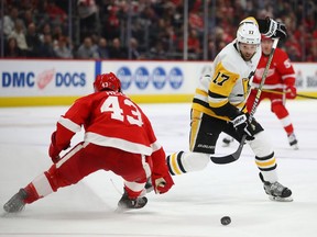 Bryan Rust #17 of the Pittsburgh Penguins tries to get around Darren Helm #43 of the Detroit Red Wings during the third period at Little Caesars Arena on April 02, 2019 in Detroit, Michigan. Detroit won the game 4-1.