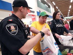 Windsor Police cadet Andrew Kovacevic, left, Special Olympics athlete Mike Skeates and Const. Lauren Brisco, right, bag groceries for customers during Pack for a Purpose at the Real Canadian Superstore on Walker Road Saturday April 20, 2019.