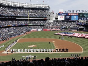 A large flag is unfurled during the national anthem before an opening day baseball game between the New York Yankees and the Baltimore Orioles at Yankee Stadium March 28, 2019, in New York.